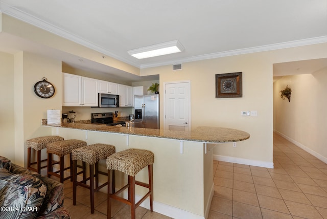 kitchen featuring crown molding, light tile patterned flooring, stainless steel appliances, white cabinetry, and kitchen peninsula