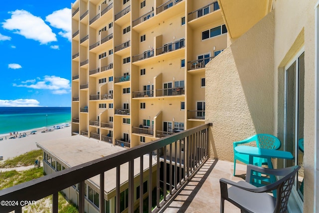 balcony featuring a beach view and a water view