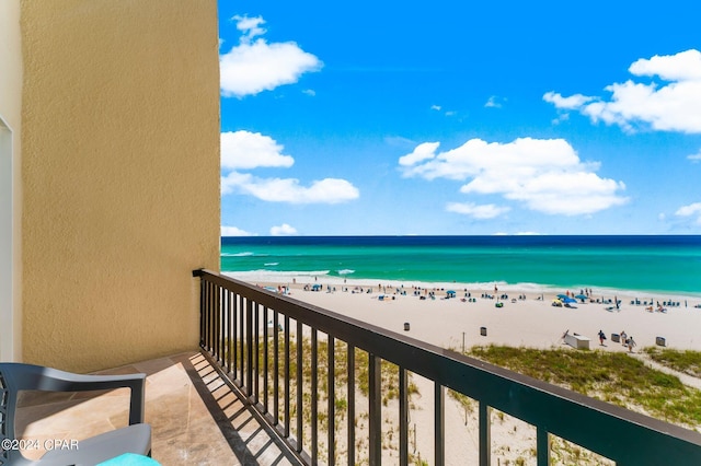 balcony with a water view and a view of the beach