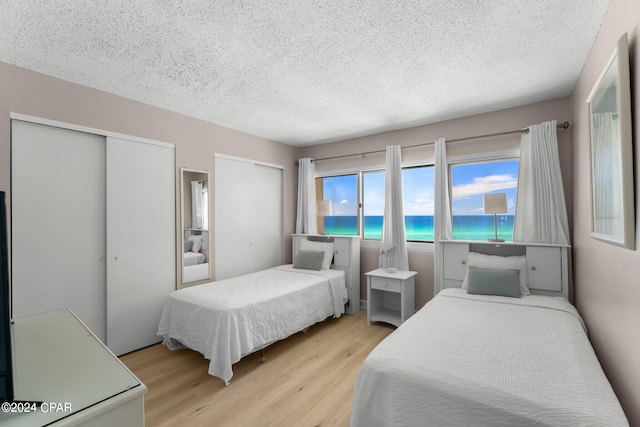 bedroom with a textured ceiling and light hardwood / wood-style flooring