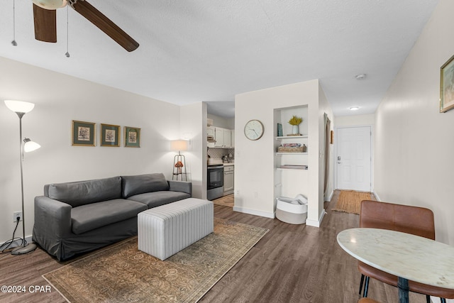 living room featuring ceiling fan, built in shelves, and wood-type flooring