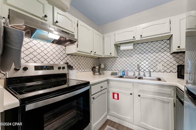 kitchen featuring backsplash, stainless steel electric range oven, sink, and white cabinetry