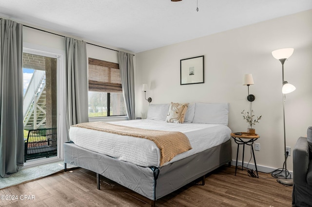 bedroom with access to outside and dark wood-type flooring