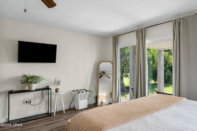 bedroom with ceiling fan, a textured ceiling, multiple windows, and hardwood / wood-style floors