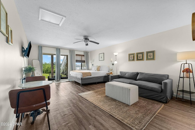 living room featuring ceiling fan, a textured ceiling, and hardwood / wood-style flooring