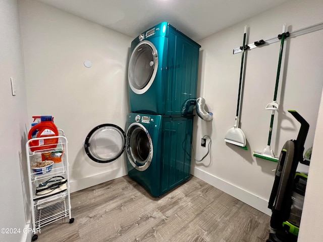 washroom with stacked washer / dryer and light hardwood / wood-style flooring