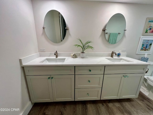 bathroom featuring hardwood / wood-style flooring, toilet, and double vanity