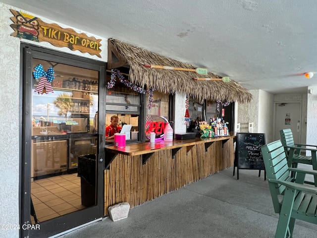 bar featuring a textured ceiling and carpet flooring