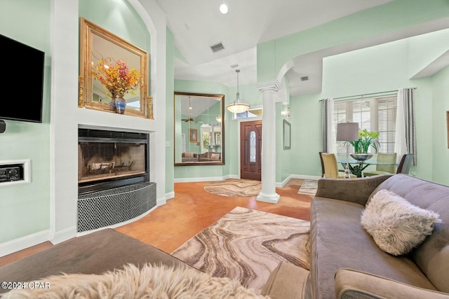 living room featuring ornate columns and vaulted ceiling