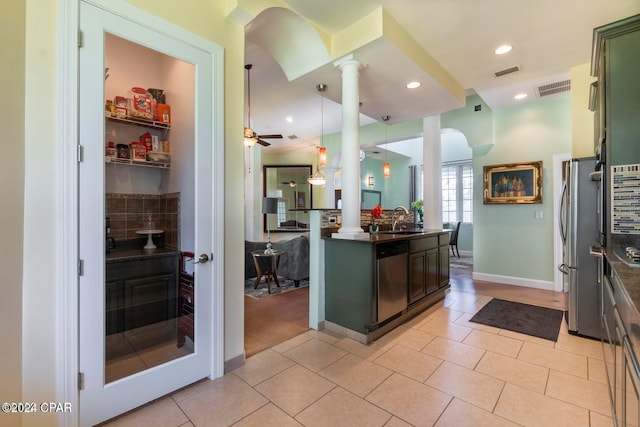 kitchen with tasteful backsplash, decorative columns, stainless steel appliances, ceiling fan, and pendant lighting