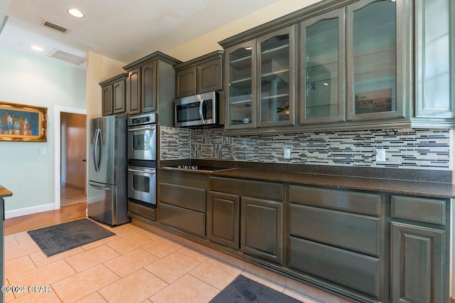 kitchen with light tile patterned floors, stainless steel appliances, and tasteful backsplash