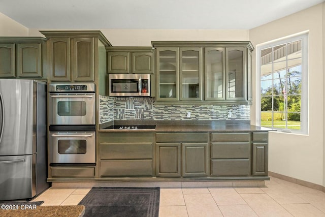 kitchen with light tile patterned floors, stainless steel appliances, and tasteful backsplash