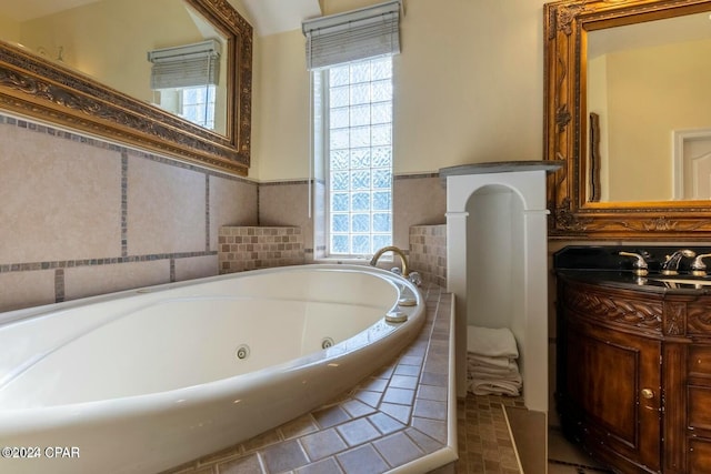 bathroom with vanity, a healthy amount of sunlight, and tiled bath