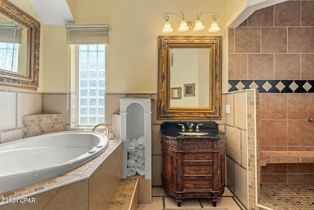 bathroom with tile patterned flooring, tiled bath, vaulted ceiling, vanity, and tile walls