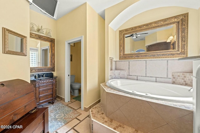 bathroom with tile patterned floors, a relaxing tiled tub, toilet, and vanity