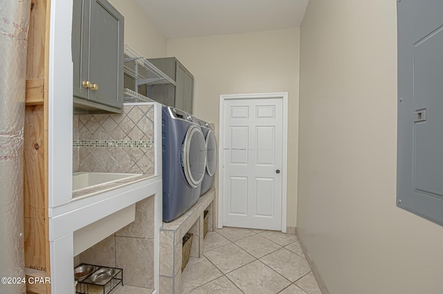 laundry room with electric panel, light tile patterned floors, cabinets, and independent washer and dryer