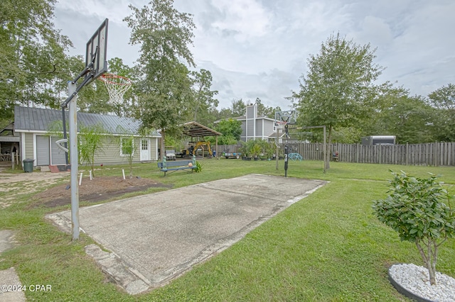 view of sport court with a lawn