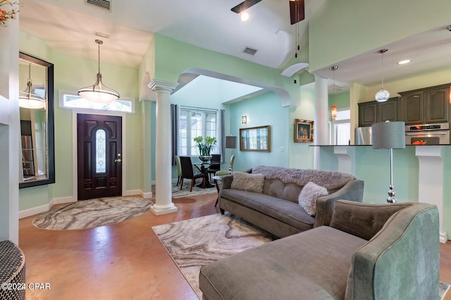 living room with ornate columns, ceiling fan, and high vaulted ceiling