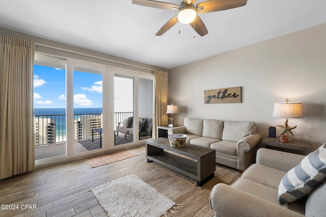 living room with a water view, ceiling fan, and light hardwood / wood-style floors