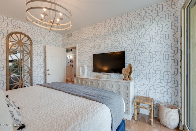 bedroom with an inviting chandelier and light hardwood / wood-style flooring