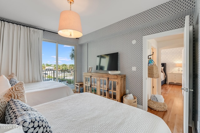 bedroom with access to outside and wood-type flooring