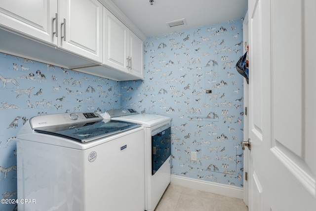 washroom with independent washer and dryer, cabinets, and light tile patterned flooring