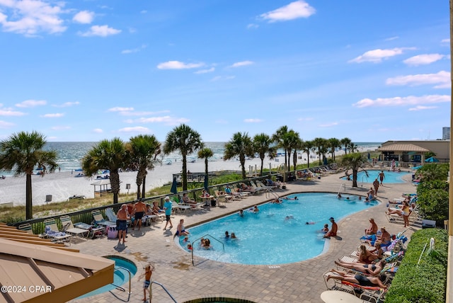 view of swimming pool featuring a patio and a water view