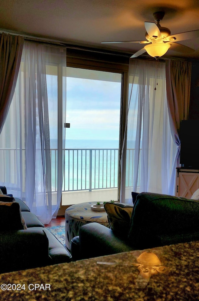 living room featuring a water view and a ceiling fan