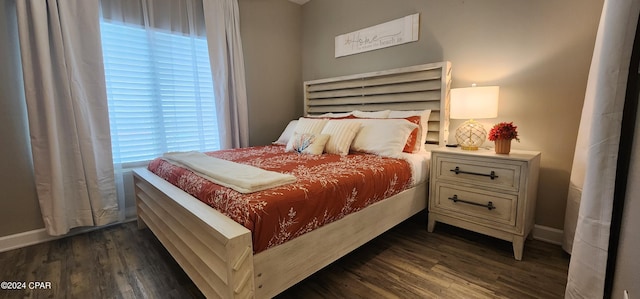 bedroom with dark wood finished floors and baseboards