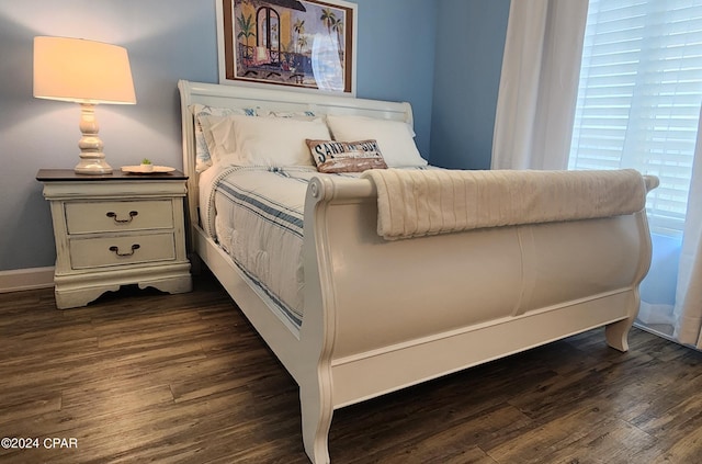 bedroom featuring baseboards and dark wood-style flooring