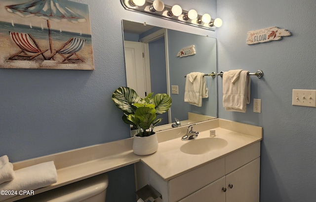 bathroom featuring a textured wall and vanity