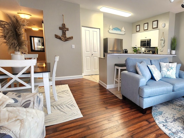 living area with baseboards and dark wood finished floors