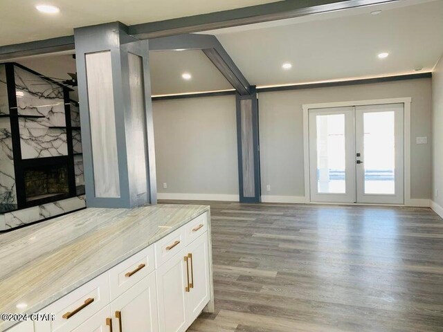 unfurnished living room featuring ceiling fan, french doors, beam ceiling, and hardwood / wood-style flooring