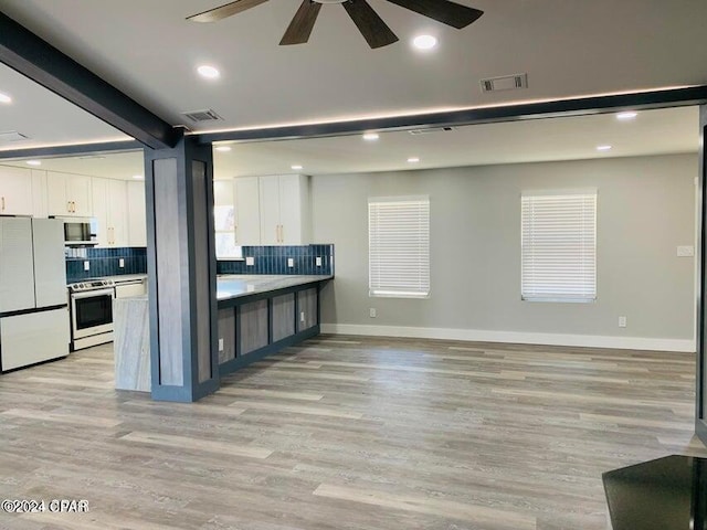 kitchen with electric stove, light hardwood / wood-style flooring, backsplash, white refrigerator, and white cabinets