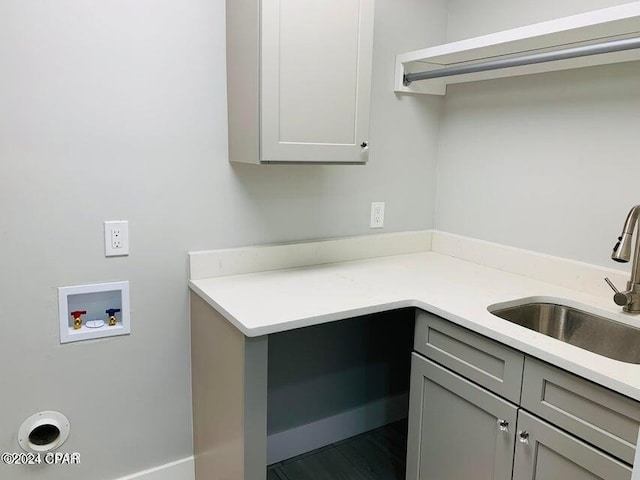 washroom featuring hookup for a washing machine, cabinets, and sink