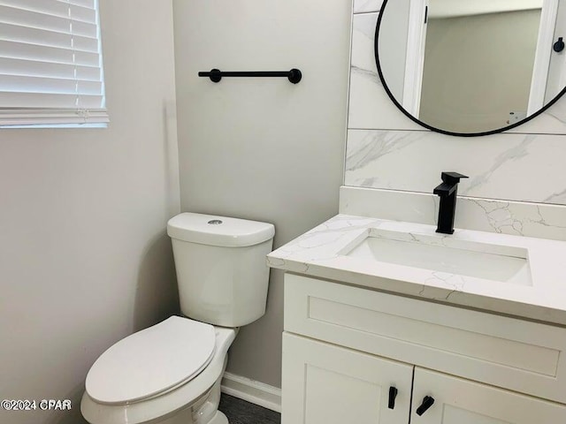 bathroom with tasteful backsplash, vanity, and toilet