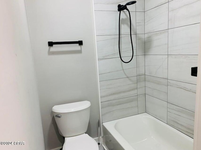 bathroom with toilet and tiled shower / bath