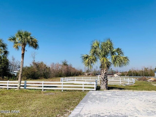 surrounding community with a rural view and a lawn