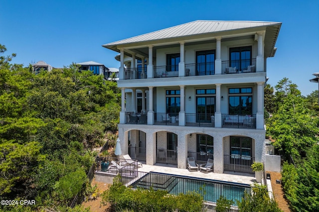 back of property with a balcony and a patio