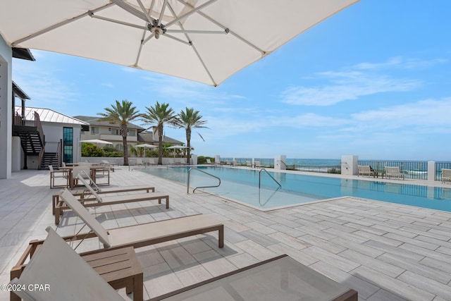 view of swimming pool with a patio and a water view