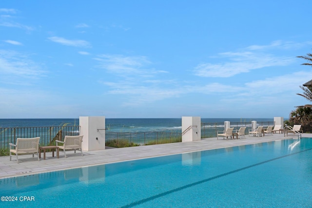 view of swimming pool with a patio area and a water view