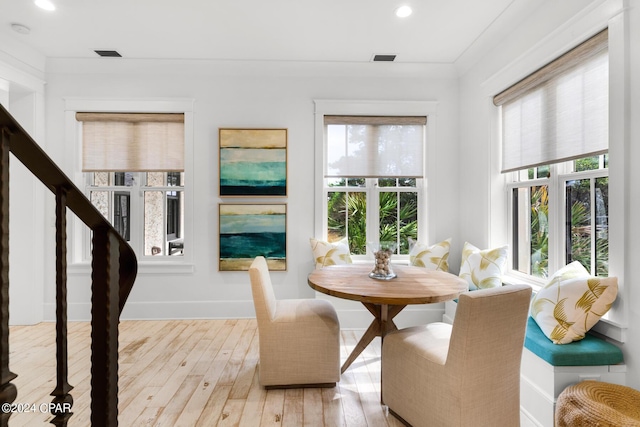 dining room with crown molding and light hardwood / wood-style floors