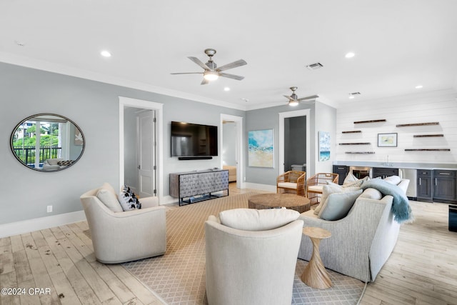 living room with ceiling fan, light wood-type flooring, and ornamental molding