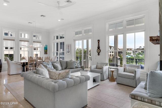 tiled living room featuring ceiling fan with notable chandelier and crown molding