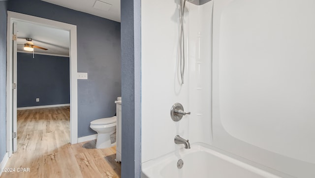 bathroom featuring toilet, hardwood / wood-style flooring, and bathtub / shower combination