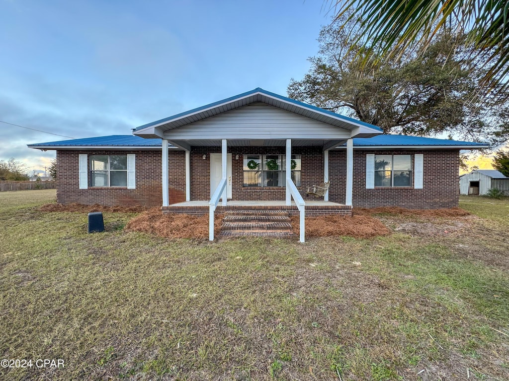 view of front of home with covered porch and a front yard