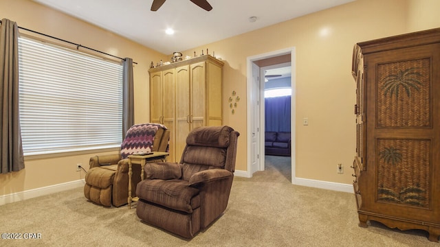 sitting room with ceiling fan and light carpet