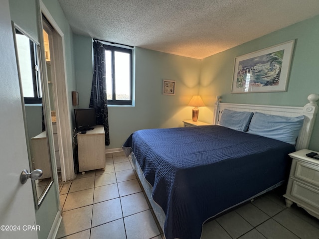 bedroom featuring a textured ceiling and light tile patterned flooring