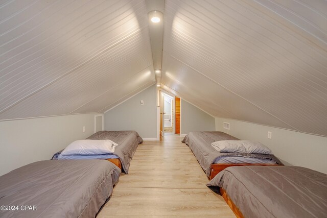 bedroom with light hardwood / wood-style floors and vaulted ceiling