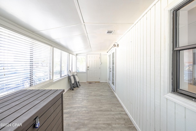 hall with light hardwood / wood-style floors and vaulted ceiling